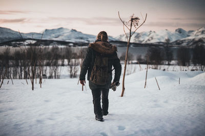 Full length portrait of man standing on snow covered landscape