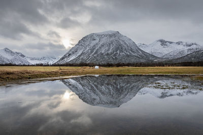 Reflection of mountain range in lake against sky