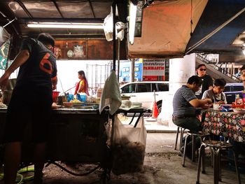 Rear view of people working at market