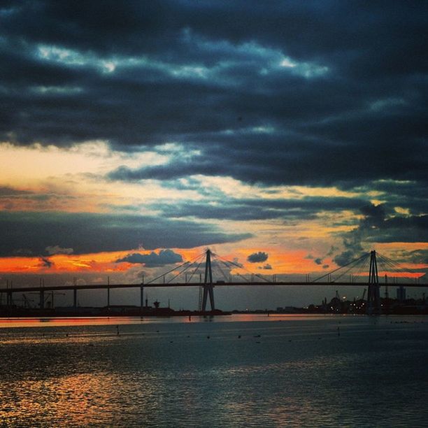 sunset, connection, bridge - man made structure, sky, water, architecture, built structure, cloud - sky, waterfront, orange color, engineering, cloudy, river, bridge, transportation, dramatic sky, sea, cloud, suspension bridge, dusk