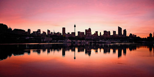 Reflection of buildings in lake during sunset