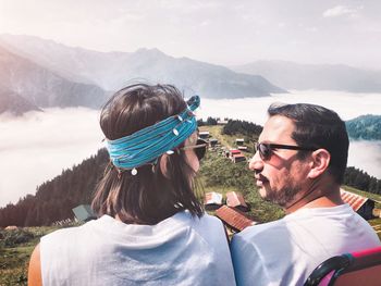 Portrait of friends on mountain against sky