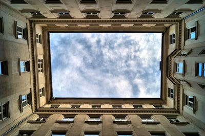 Patio and low angle view of building against sky