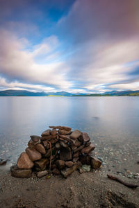 Surface level of pebbles on beach against sky