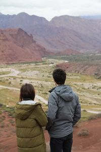 Rear view of couple standing on mountain landscape