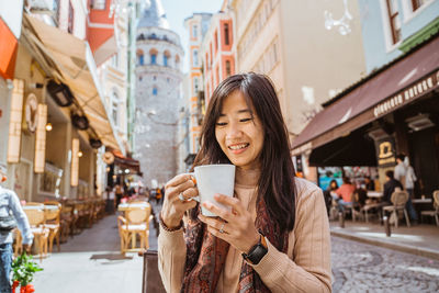 Portrait of young woman in city