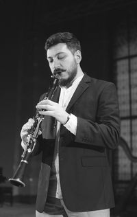Man playing clarinet while standing at studio