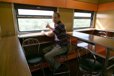 Side view of young man sitting on seat