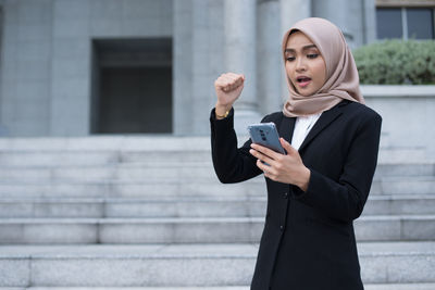 Full length of a young woman using mobile phone