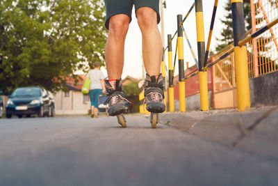 Low section of man roller skating on road in city