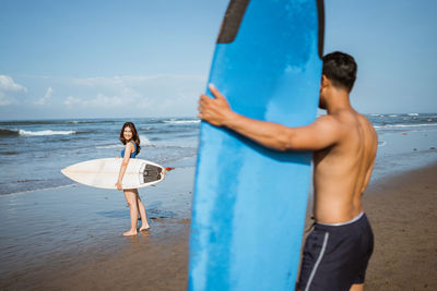 Rear view of woman standing at beach