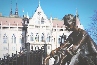 Statue in city against clear sky