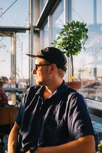 Man looking away while sitting in restaurant