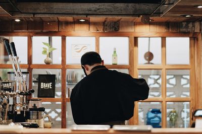 Rear view of barista working in caf