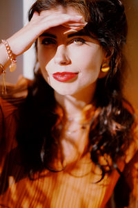 Close-up portrait of beautiful young woman shielding eyes