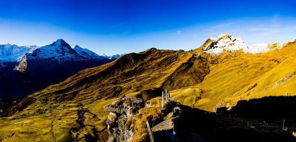 Scenic view of mountains against blue sky