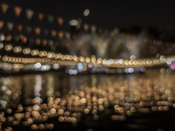 Defocused image of illuminated lights in city at night