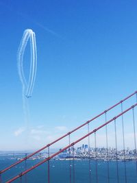 Low angle view of airplane flying against clear blue sky