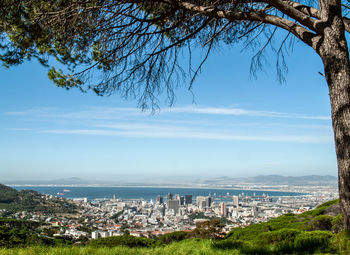 Aerial view of city by sea against sky