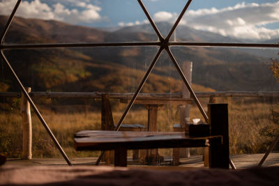 Close-up view of the veranda through the window against the mountains