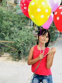 Midsection of a girl holding balloons