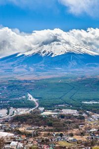 Aerial view of landscape and mountains against blue sky