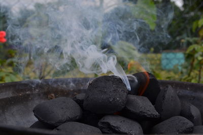 Close-up of burning coals emitting smoke