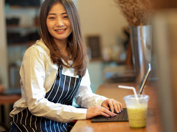 Young woman holding ice cream in restaurant