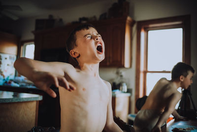 Side view of shirtless man at home