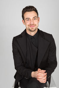 Portrait of young man standing against white background