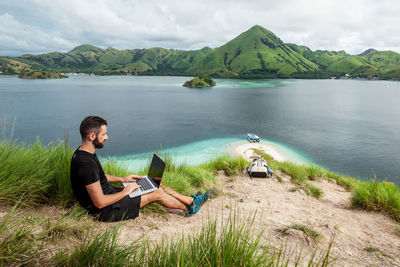 A man with a laptop working remotely on the tropical island