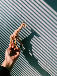 Cropped image of hand holding giraffe toy