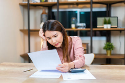 Businesswoman using laptop while sitting on table