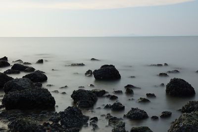 Rocks in sea against sky