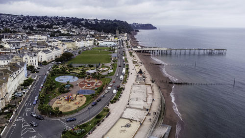 High angle view of city by sea against sky