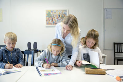 Teacher helping children in classroom