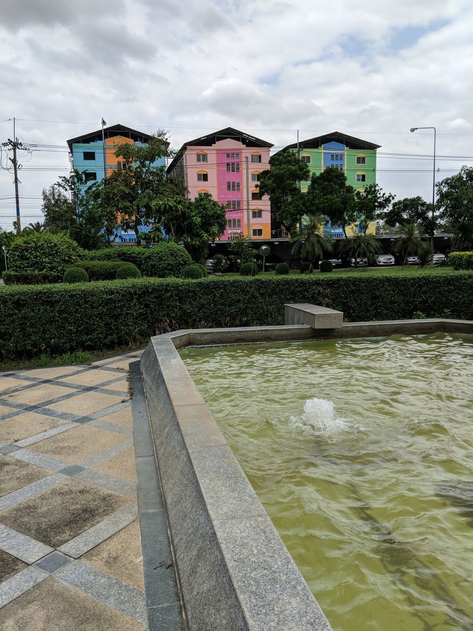 SWIMMING POOL BY RIVER AND BUILDINGS AGAINST SKY