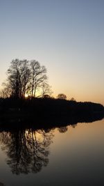 Reflection of trees in lake against sky during sunset
