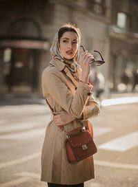 Fashionable woman standing against building in city