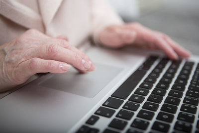 Senior woman using laptop touchpad