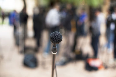 Close-up of microphone with journalist standing in background