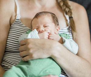 Midsection of mother with sleeping baby