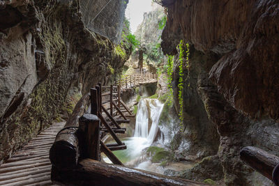 Walkway over waterfalls in caves carved out of sandstone