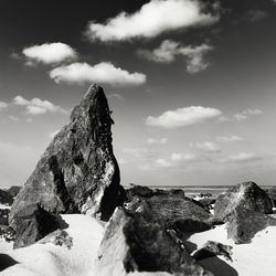 Rock formation in sea against sky