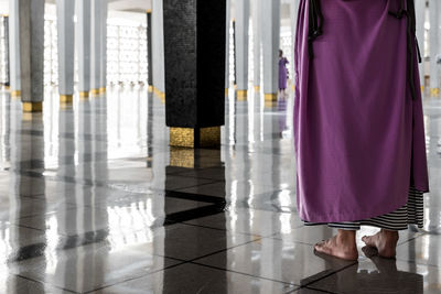 Low section of man standing on tiled floor