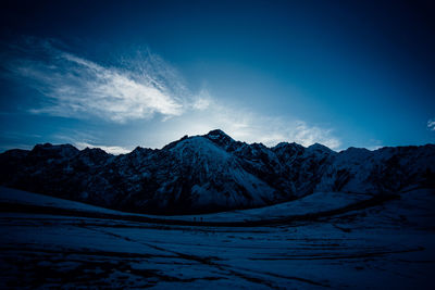 Scenic view of snowcapped mountains against blue sky