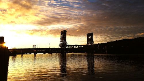 Bridge over river at sunset