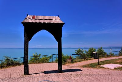 Built structure by trees against blue sky