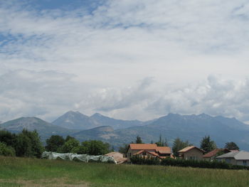 Houses by mountains against sky