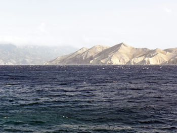 Scenic view of sea and mountains against sky